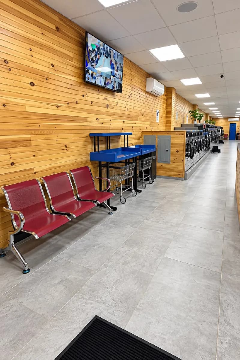 Wide aisle with a TV, red benches and folding tables