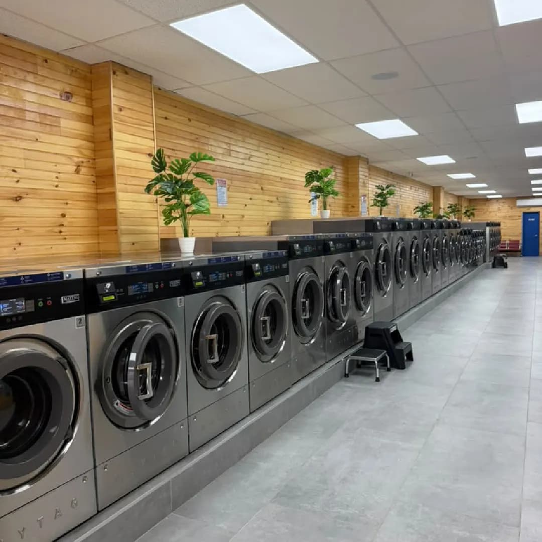 Row of Maytag washers inside TOP Laundromat on Jamaica Ave